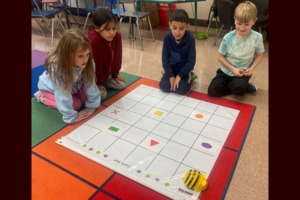  students interacting with a BeeBot